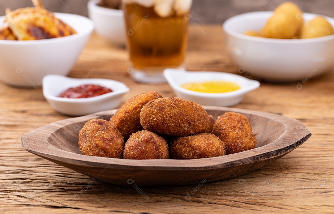 Lanche típico recheado de carne brasileira em um prato com copo de refrigerante, ketchup e mostarda.