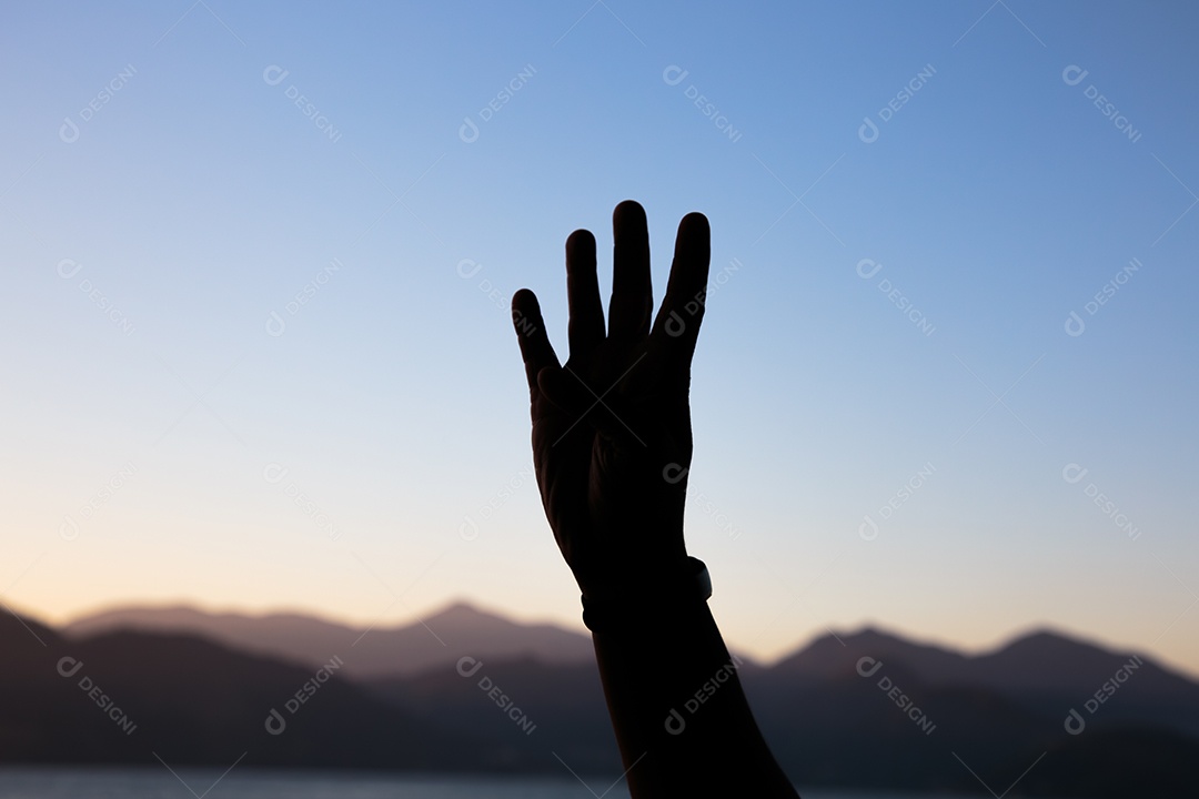 Silhueta de mãos em forma de número quatro com um lindo céu colorido de fim de tarde no Rio de Janeiro
