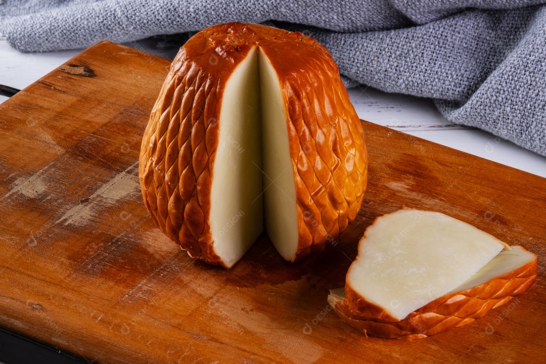 Provolone defumado feito com leite de búfala em tábua de madeira.