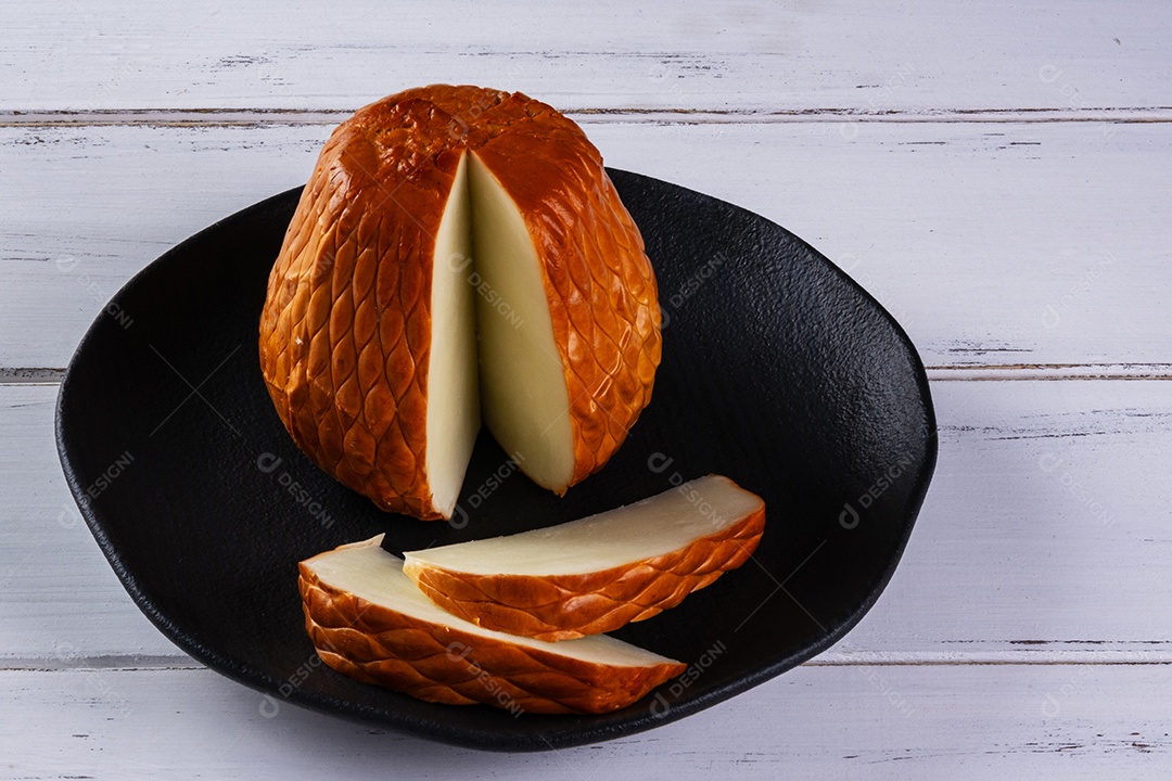 Provolone defumado feito com leite de búfala em tábua de madeira.
