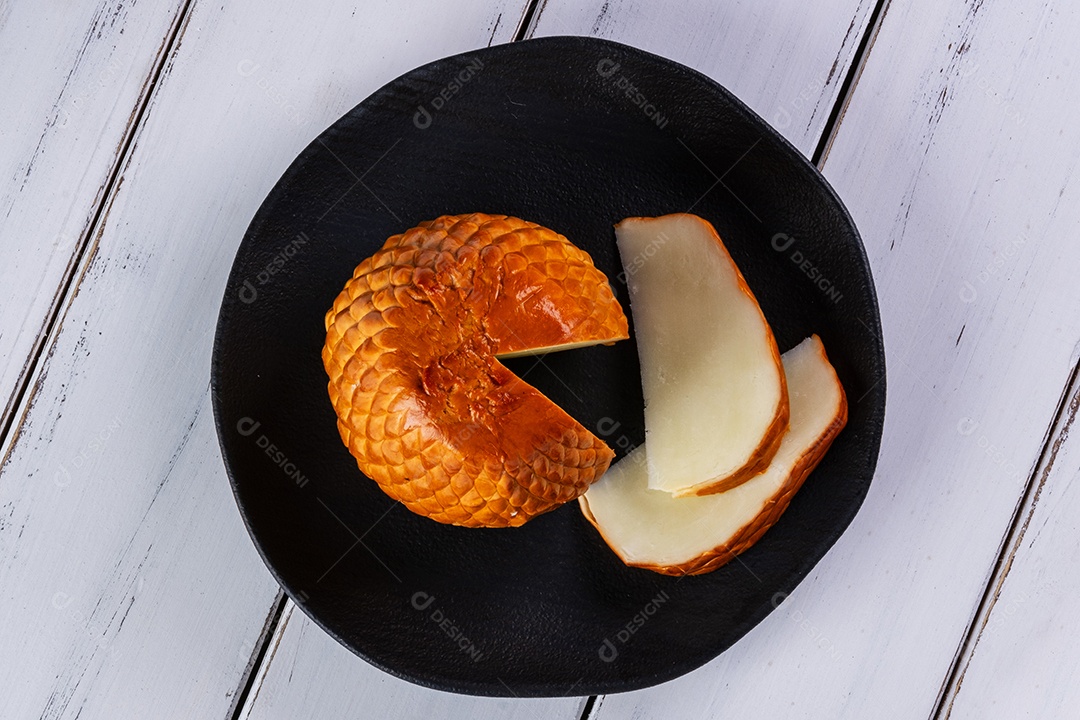 Provolone defumado feito com leite de búfala em tábua de madeira.