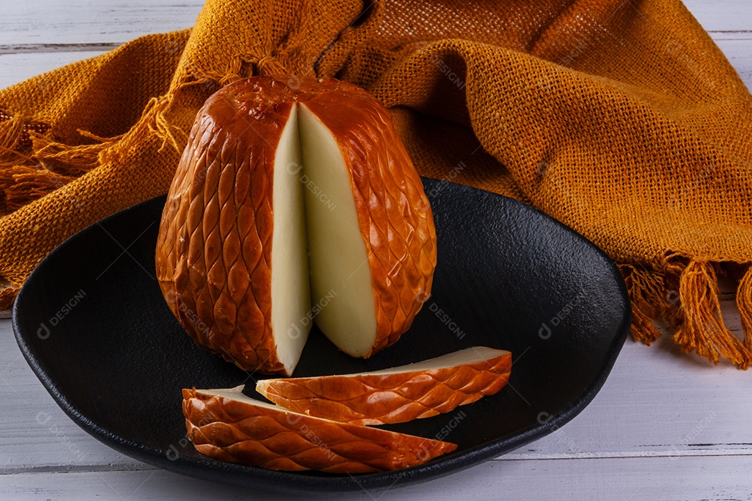 Provolone defumado feito com leite de búfala em tábua de madeira.