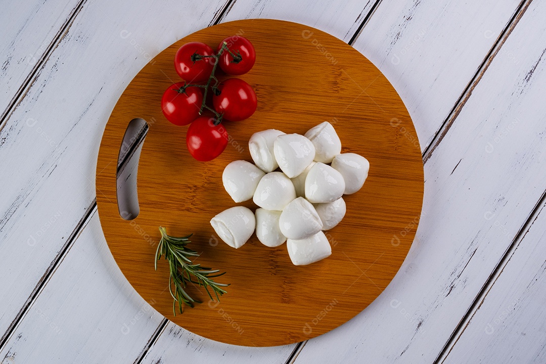 Tábua redonda com bolinhas de mussarela de búfala e tomate cereja.