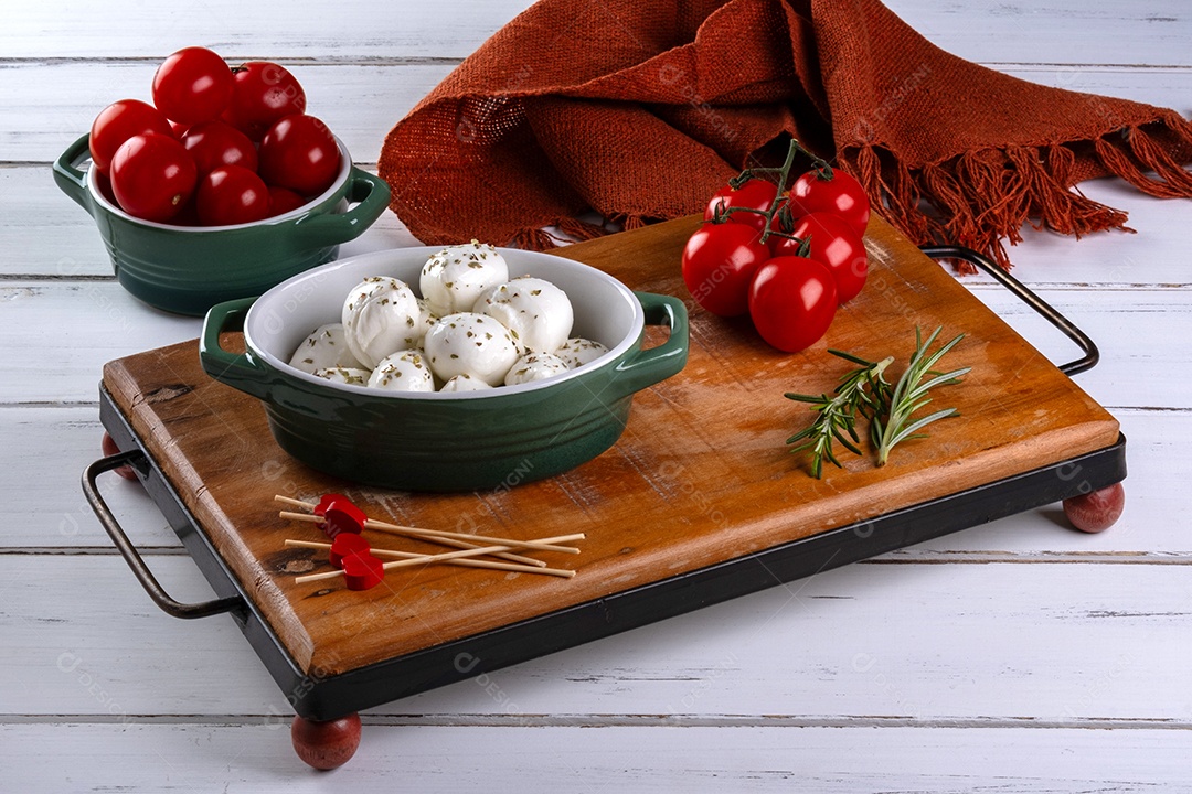 Tábua redonda com bolinhas de mussarela de búfala e tomate cereja.