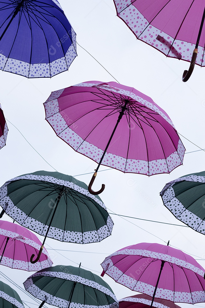 Guarda chuvas coloridos sobre uma rua