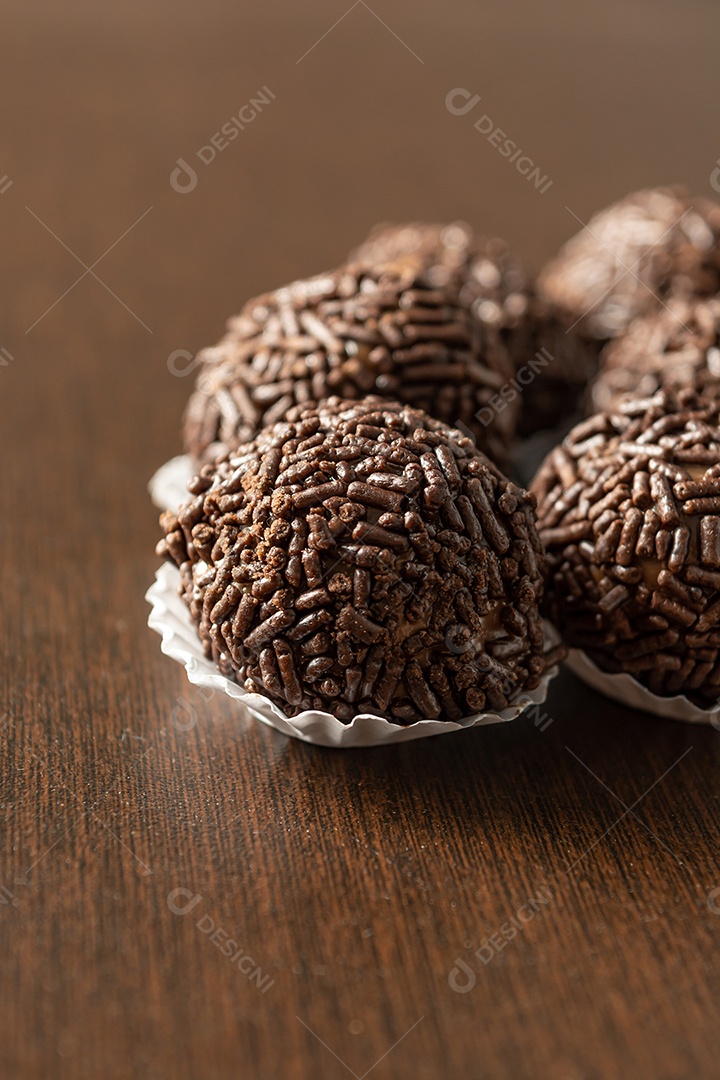 Brigadeiro brasileiro com chocolate granulado em uma mesa de madeira.