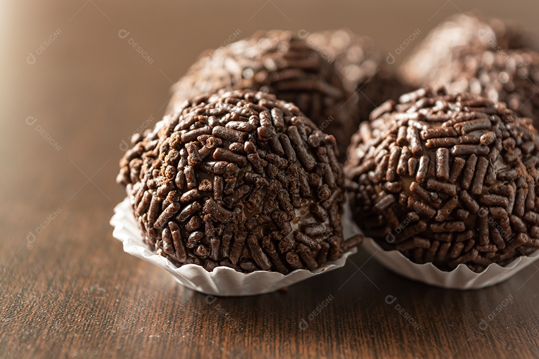 Brigadeiro brasileiro com chocolate granulado em uma mesa de madeira.