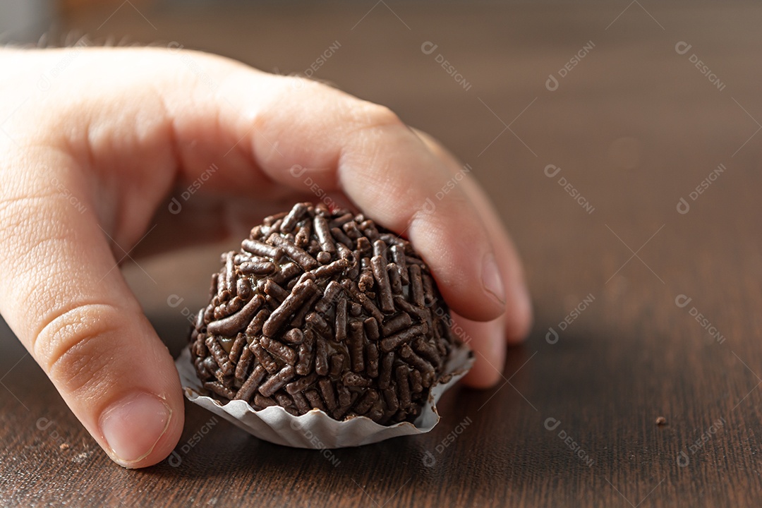 Brigadeiro brasileiro com chocolate granulado em uma mesa de madeira.