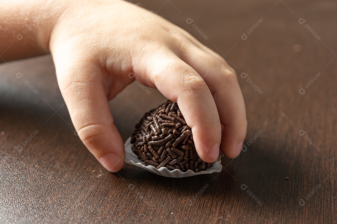 Brigadeiro brasileiro com chocolate granulado em uma mesa de madeira.