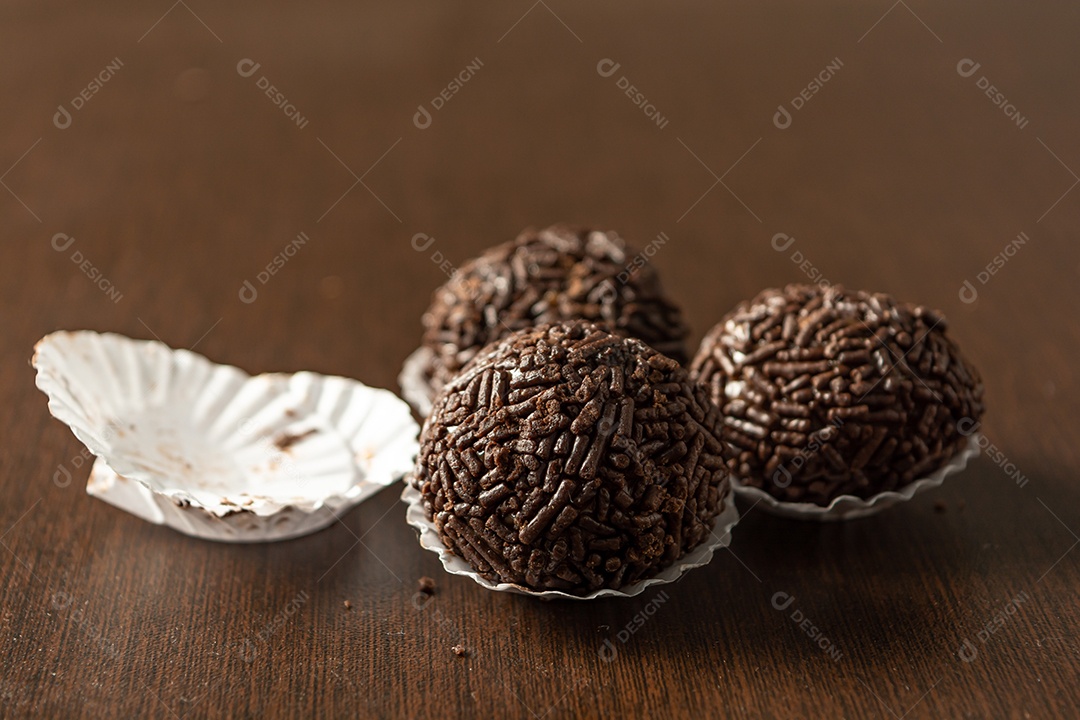 Brigadeiro brasileiro com chocolate granulado em uma mesa de madeira.