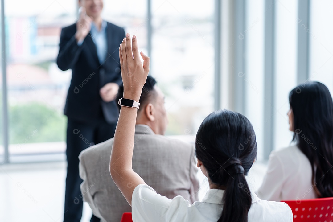 Pessoa de negócios levantando a mão durante o seminário.