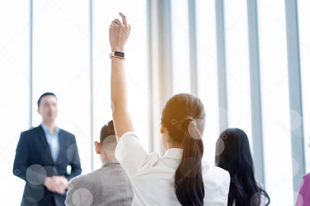 Pessoa de negócios levantando a mão durante o seminário.