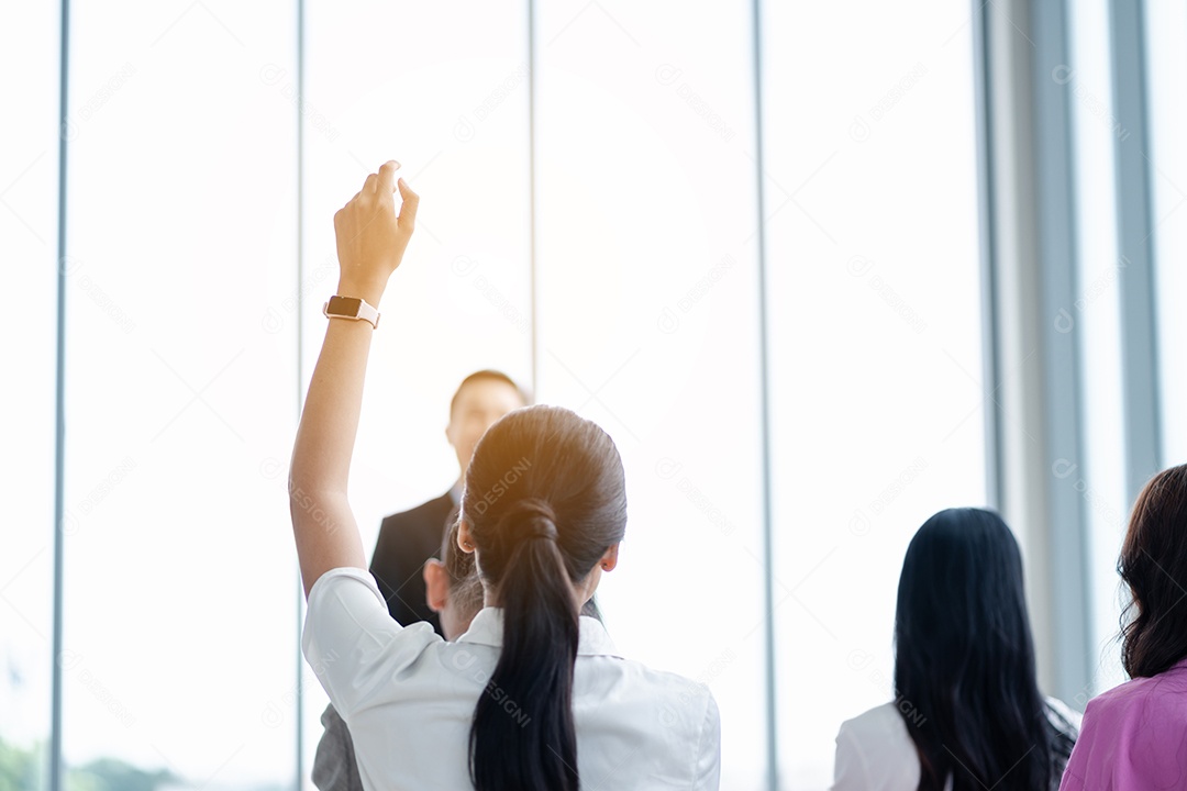 Pessoa de negócios levantando a mão durante o seminário.