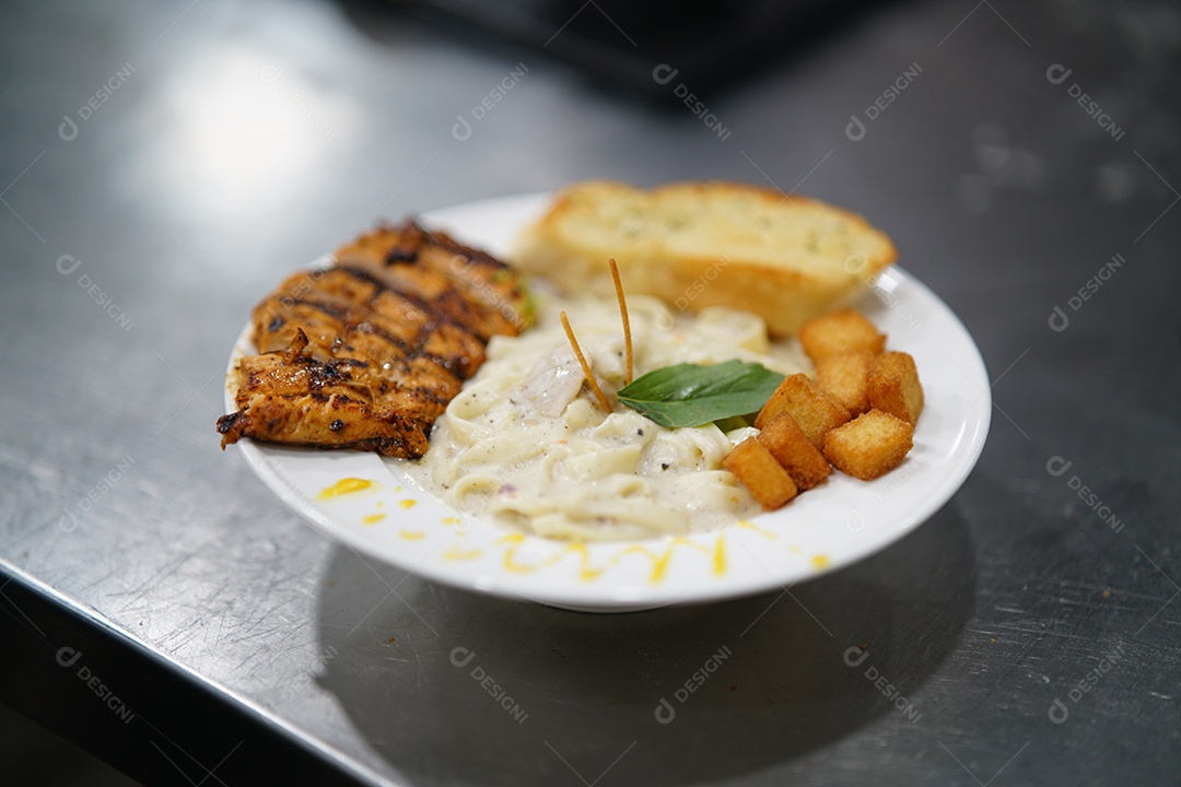 Prato com delicioso fettuccine Alfredo com frango grelhado