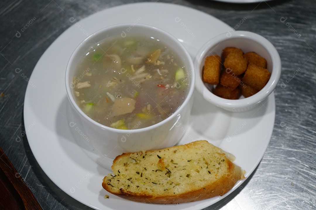 Tigela com caldo de frango delicioso com acompanhamentos