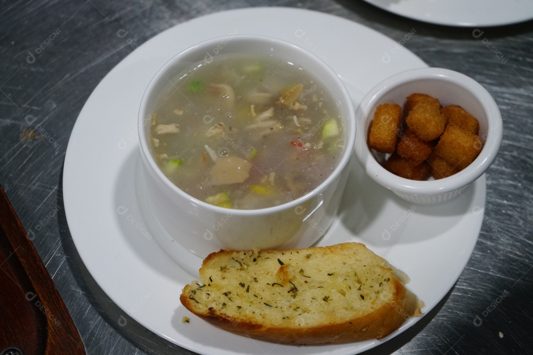 Tigela com caldo de frango delicioso com acompanhamentos