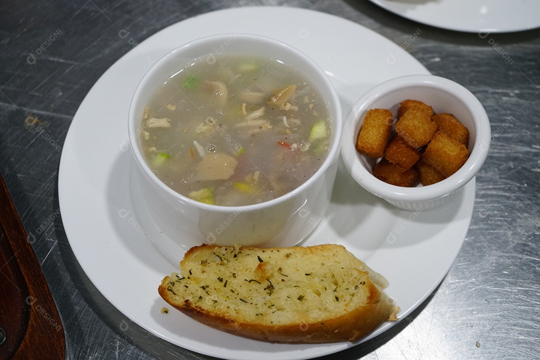 Tigela com caldo de frango delicioso com acompanhamentos