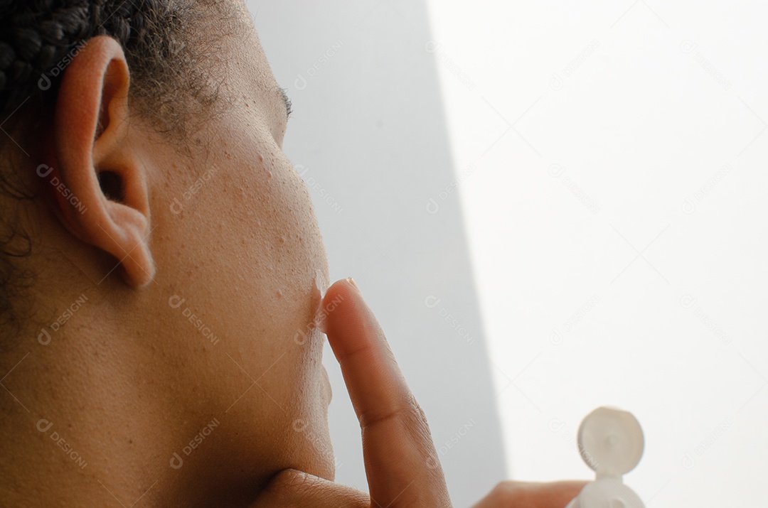 Mãos suaves em ação, massageando o rosto com creme hidratant