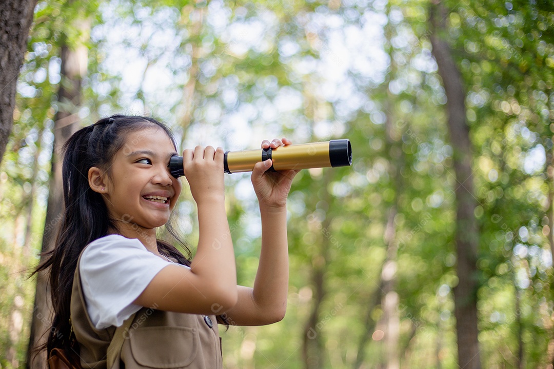 Felizes meninas asiáticas olhando para frente e sorrindo criança com os binóculos no parque.