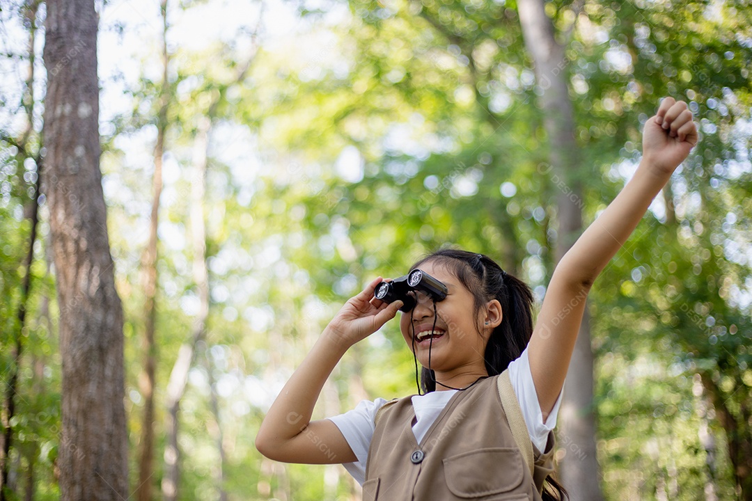 Felizes meninas asiáticas olhando para frente e sorrindo criança com os binóculos no parque.