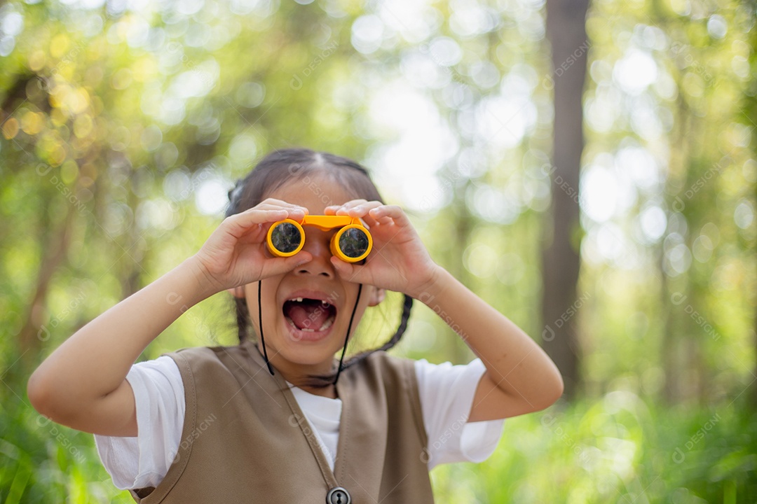 Felizes meninas asiáticas olhando para frente e sorrindo criança com os binóculos no parque.