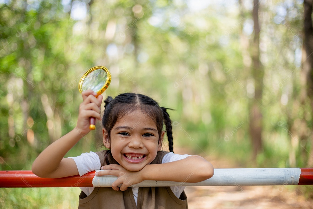 Felizes meninas asiáticas olhando para frente e sorrindo criança com os binóculos no parque.