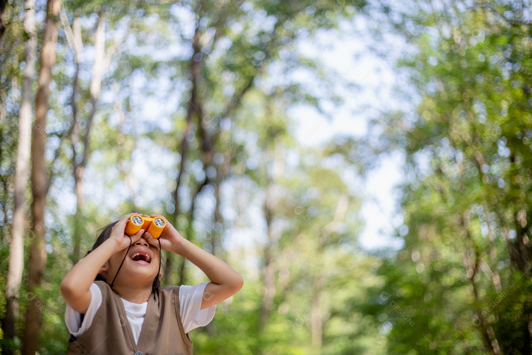 Felizes meninas asiáticas olhando para frente e sorrindo criança com os binóculos no parque.