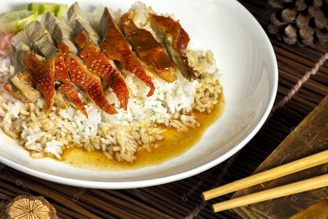 Arroz de pato assado coberto com molho em um prato branco