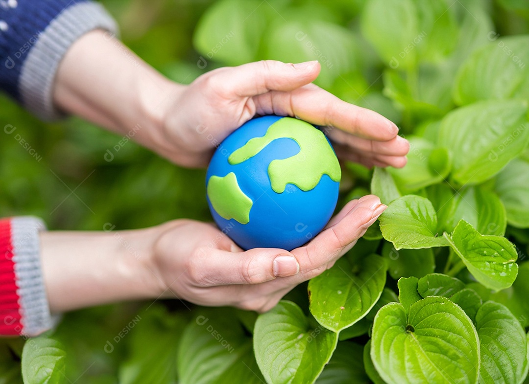 Planeta Terra nas mãos e folhas verdes