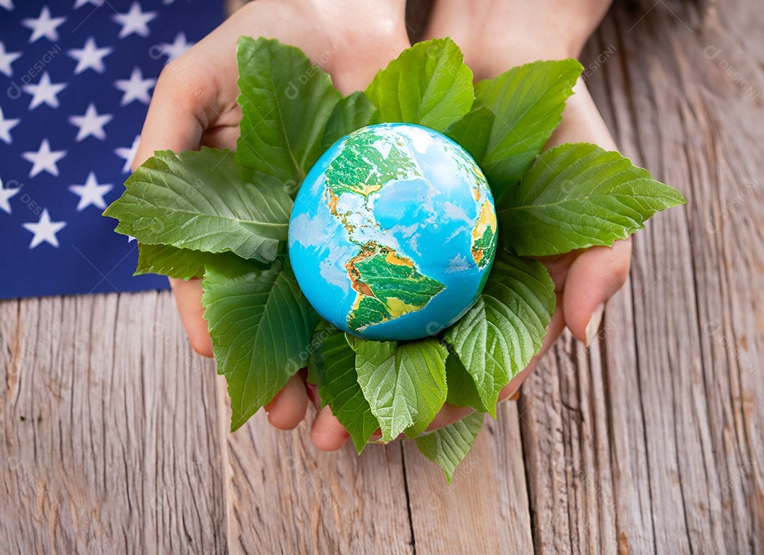 Planeta Terra nas mãos e folhas verdes