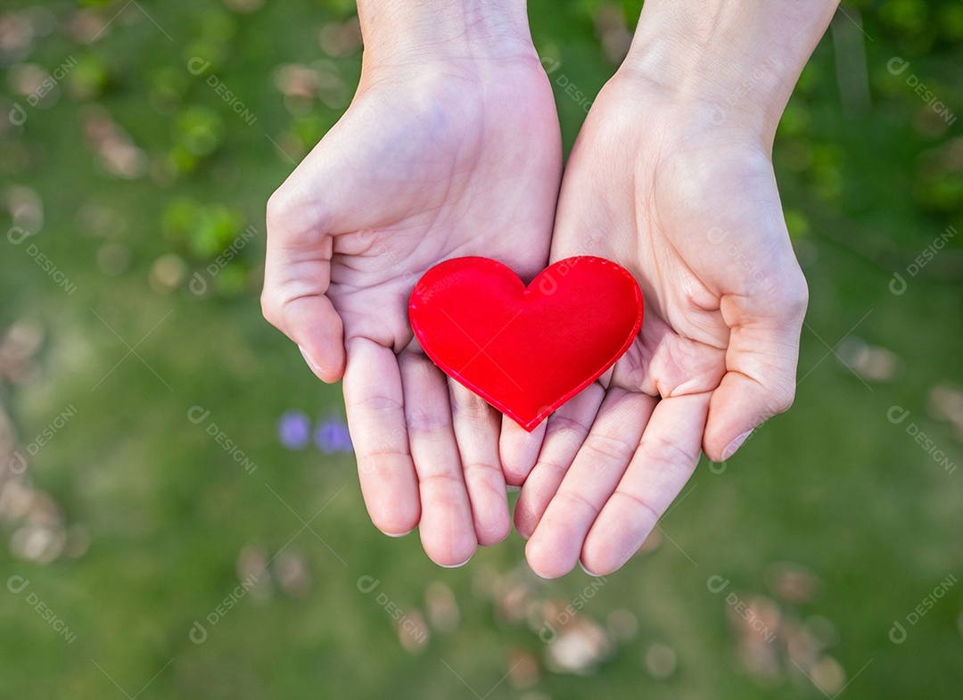 Mãos segurando um coração vermelho