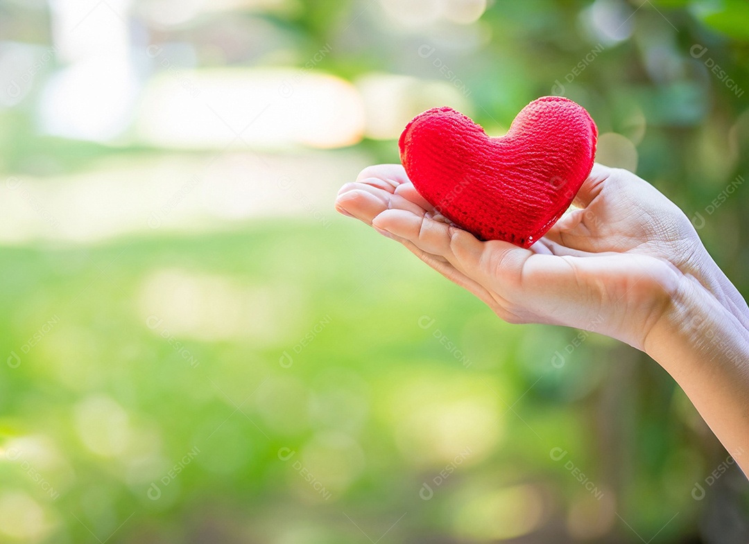 Mãos segurando um coração vermelho