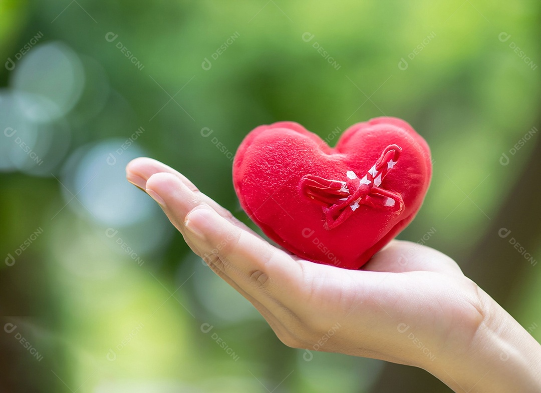 Mãos segurando um coração vermelho