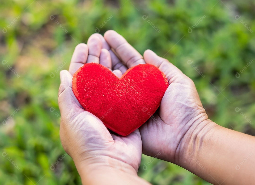Mãos segurando um coração vermelho