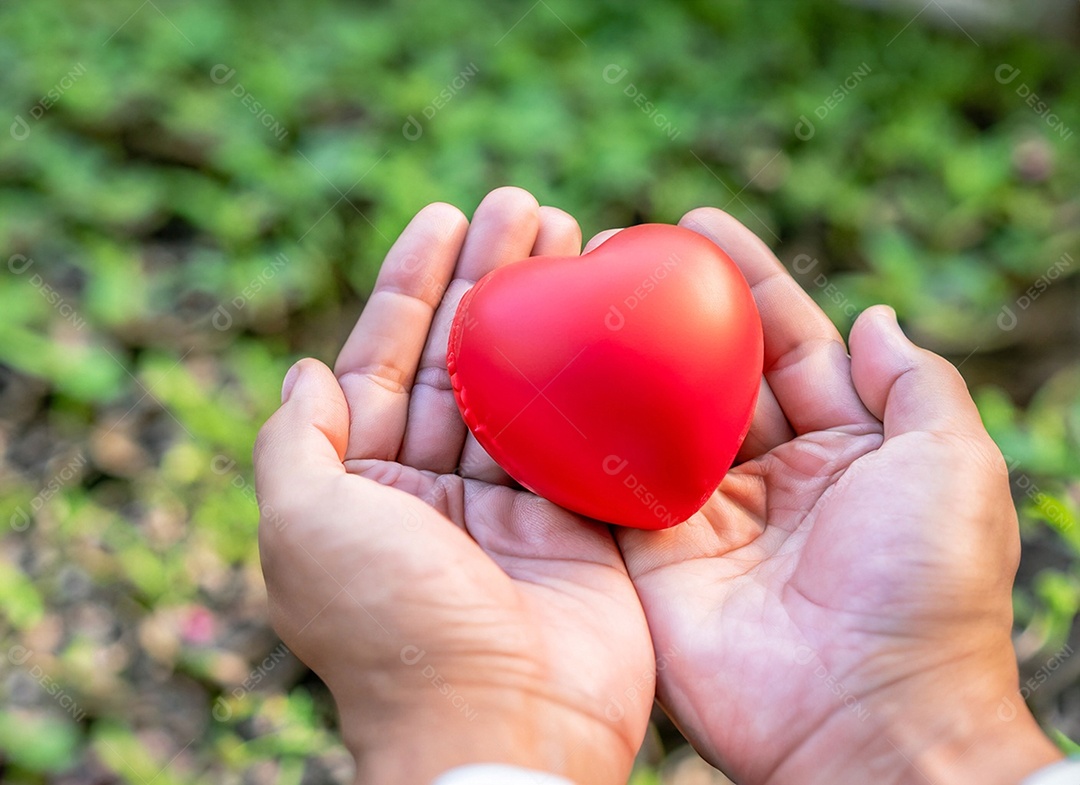 Mãos segurando um coração vermelho