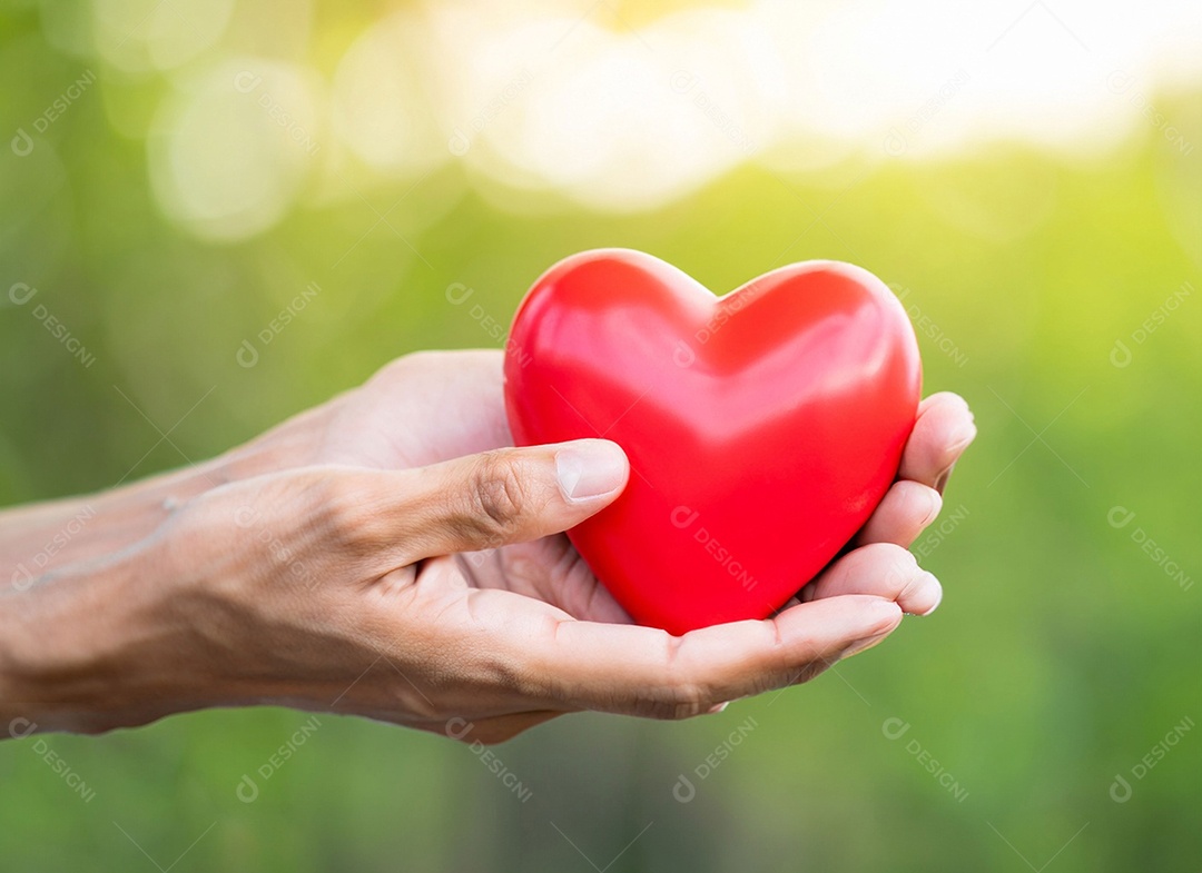 Mãos segurando um coração vermelho