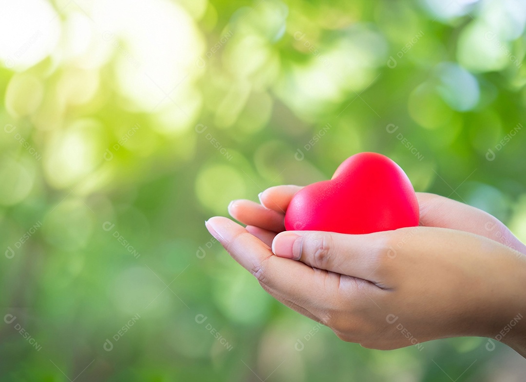 Mãos segurando um coração vermelho