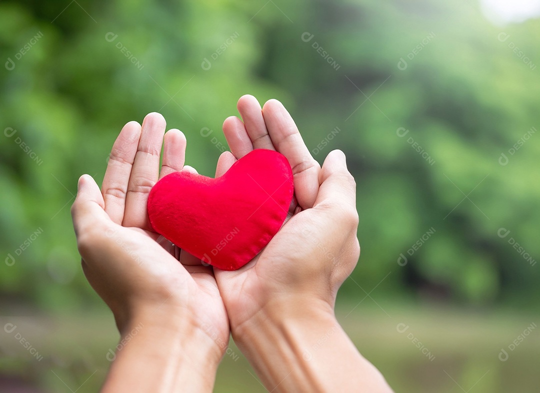 Mãos segurando um coração vermelho
