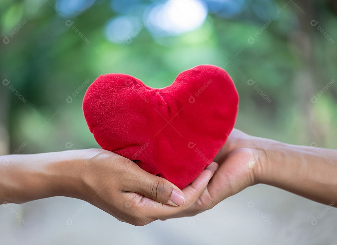 Mãos segurando um coração vermelho