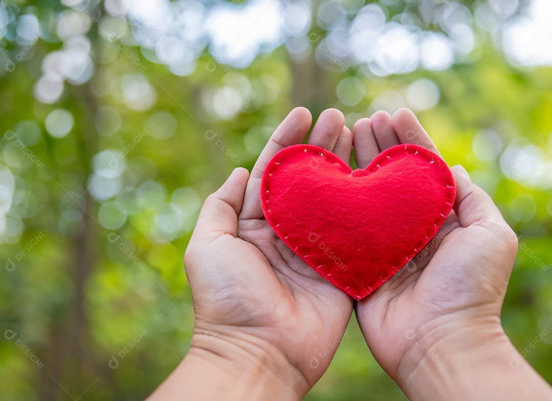 Mãos segurando um coração vermelho