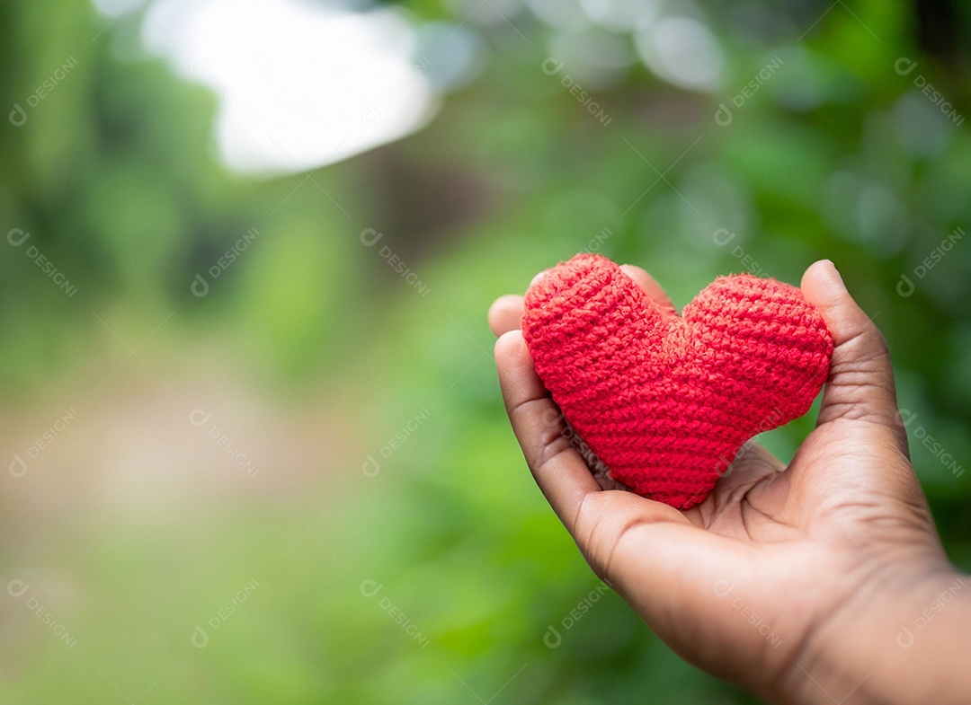 Mãos segurando um coração vermelho