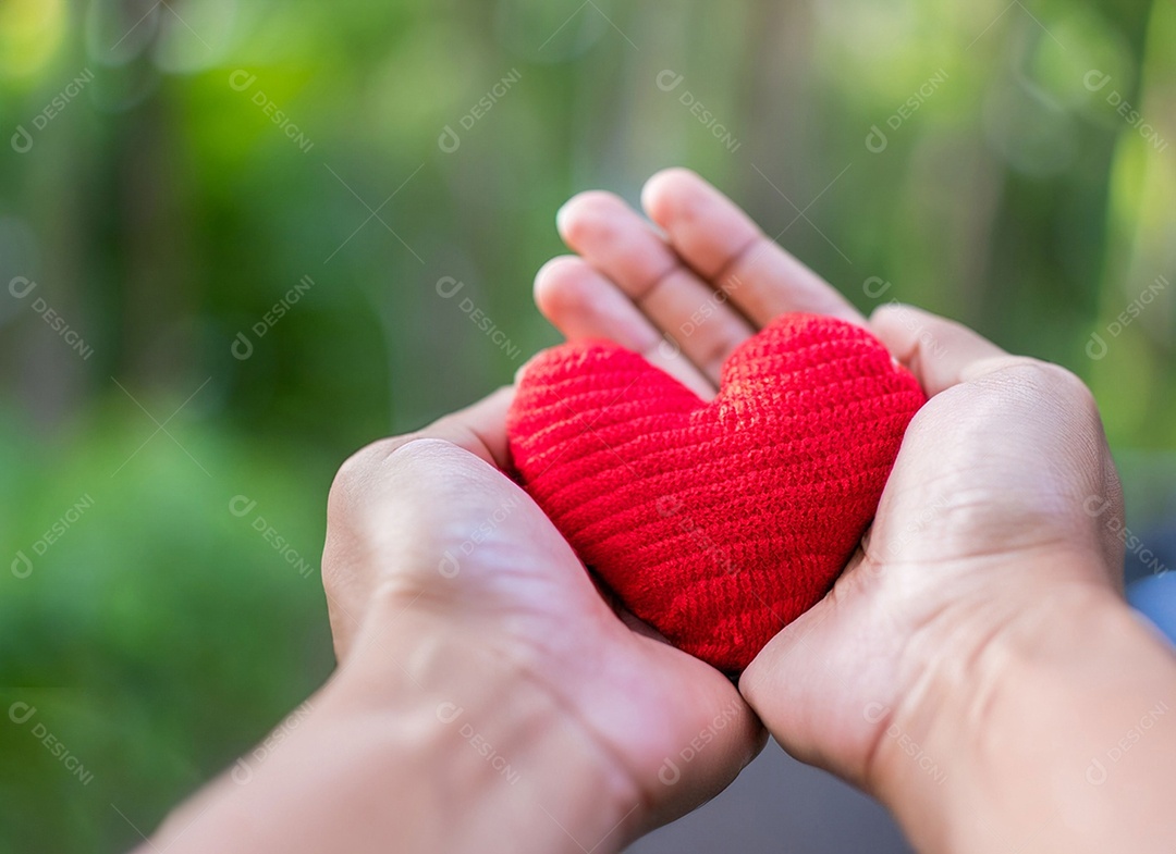 Mãos segurando um coração vermelho