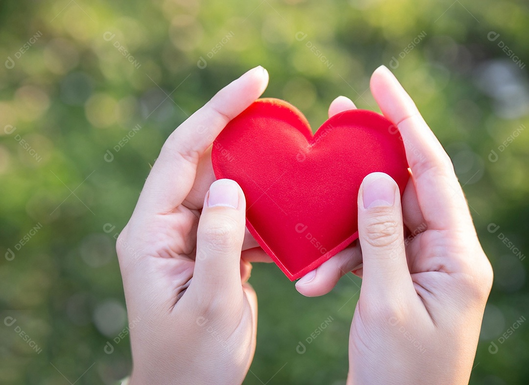 Mãos segurando um coração vermelho