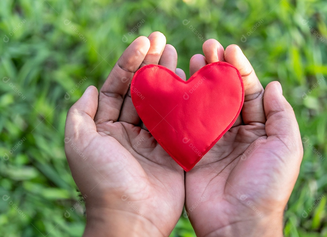 Mãos segurando um coração vermelho