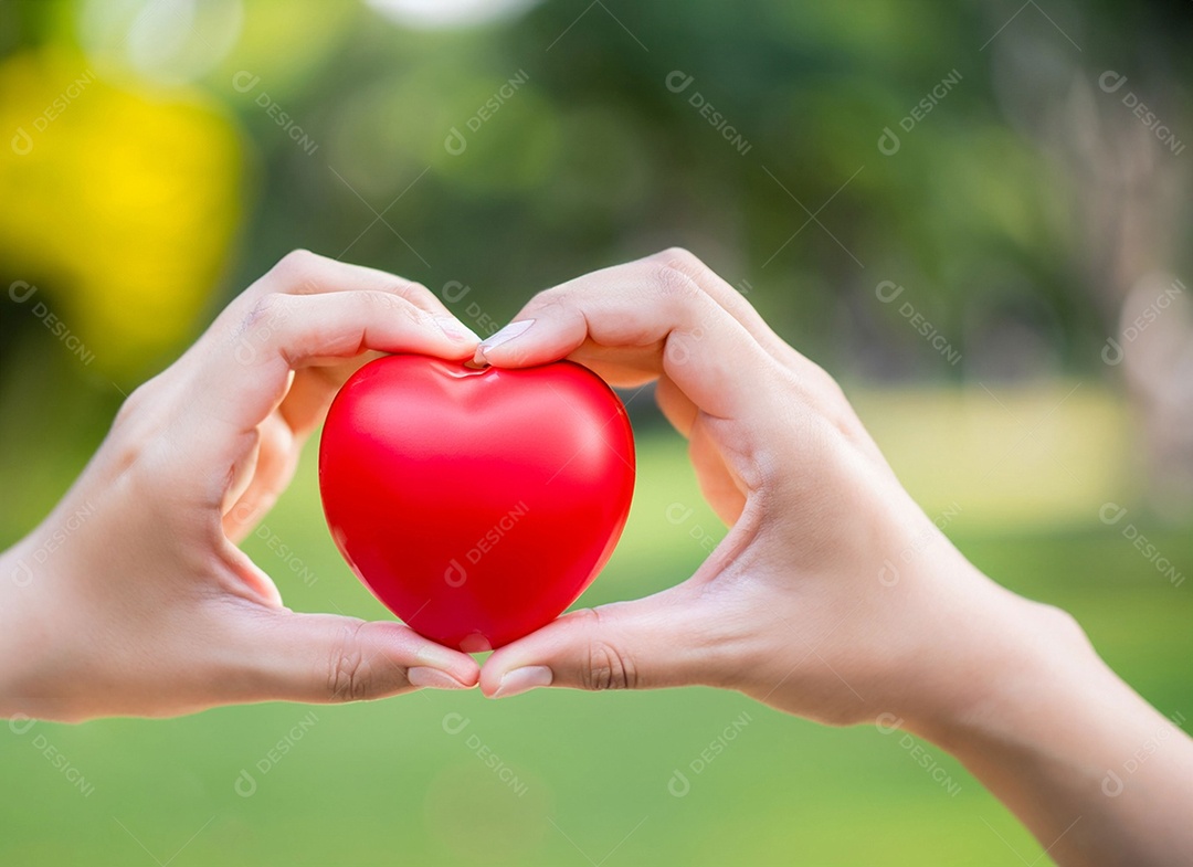 Mãos segurando um coração vermelho