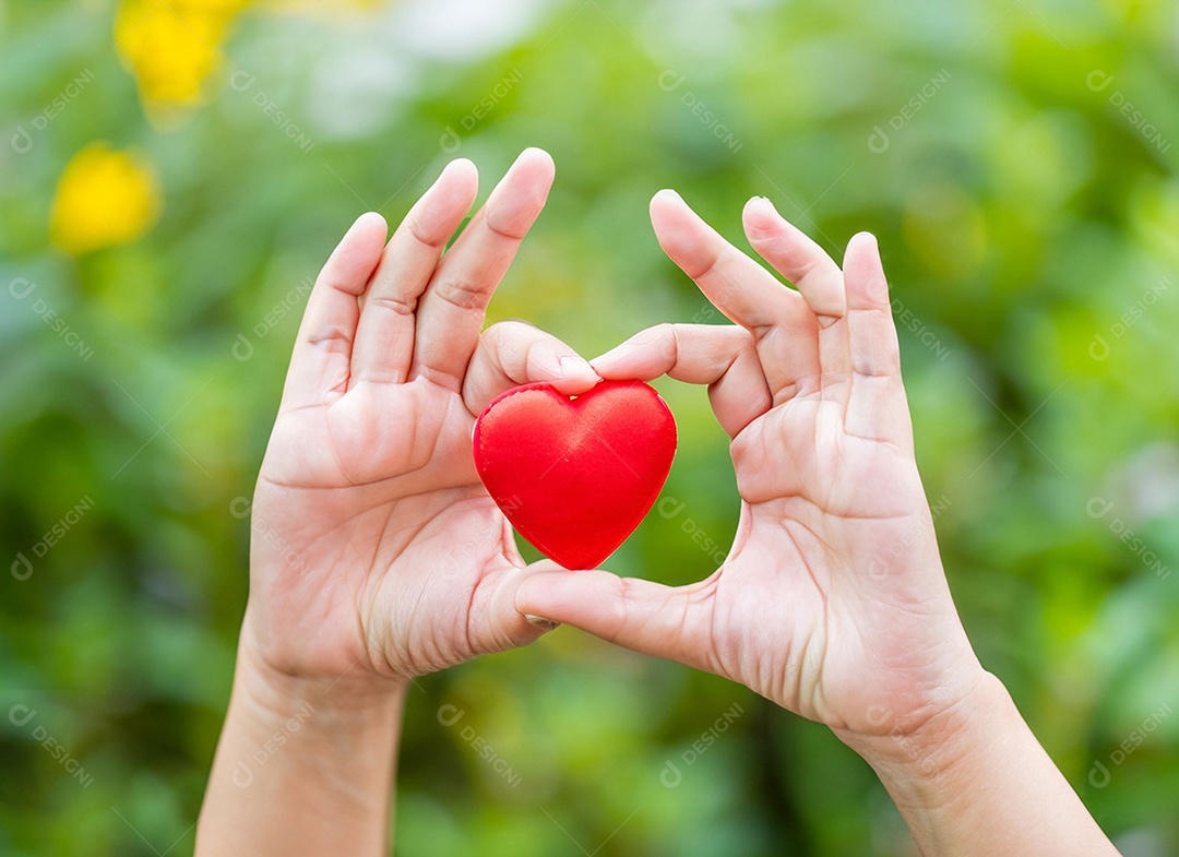 Mãos segurando um coração vermelho