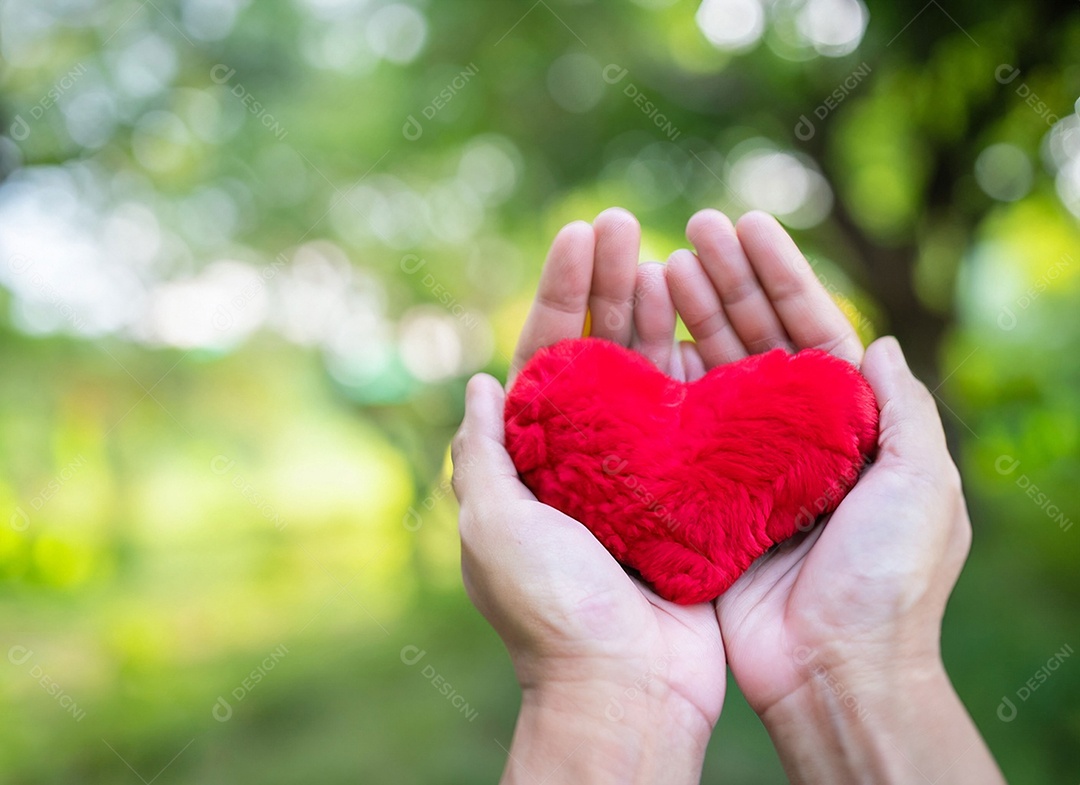 Mãos segurando um coração vermelho