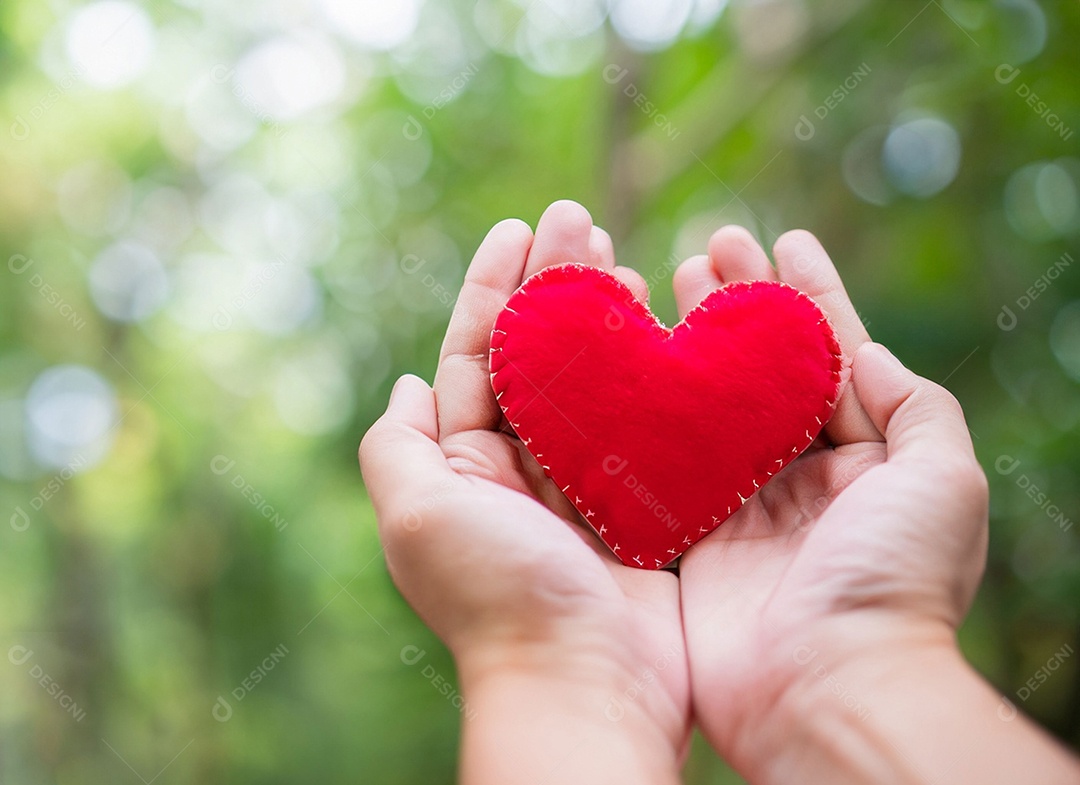 Mãos segurando um coração vermelho