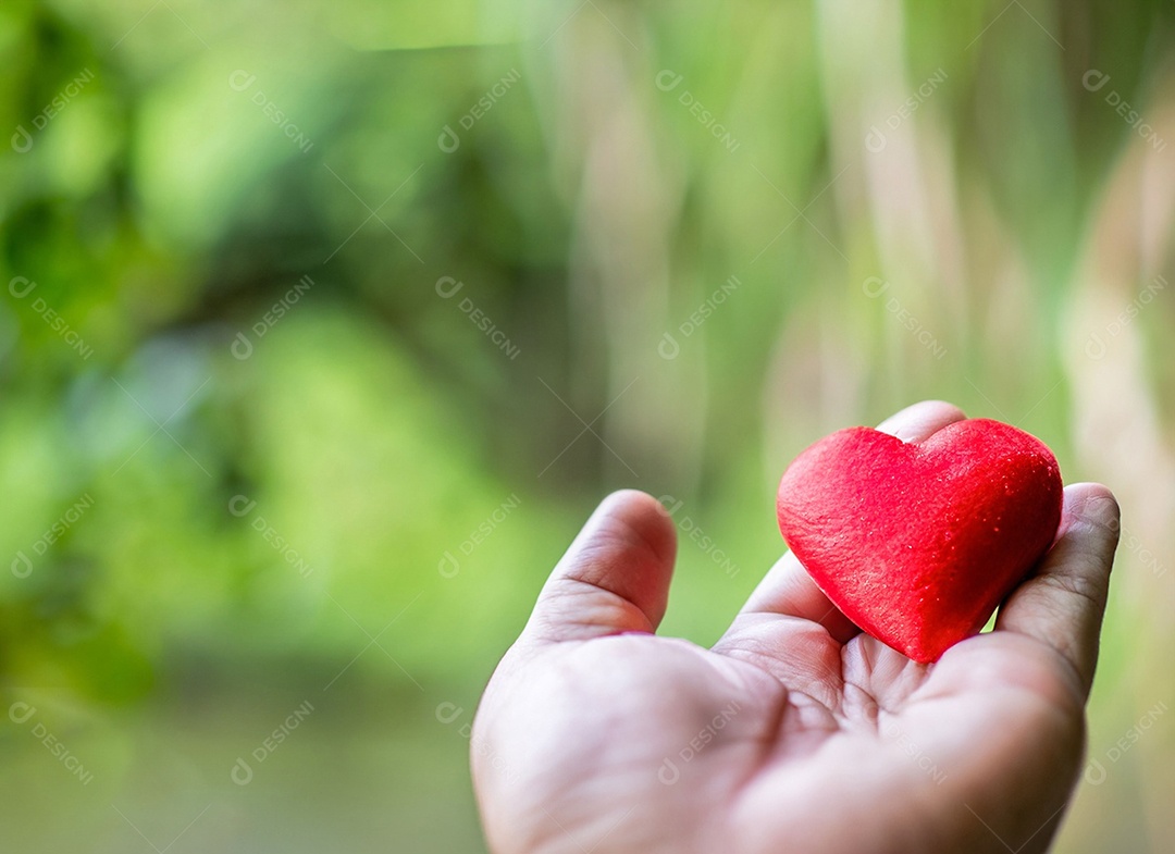 Mãos segurando um coração vermelho