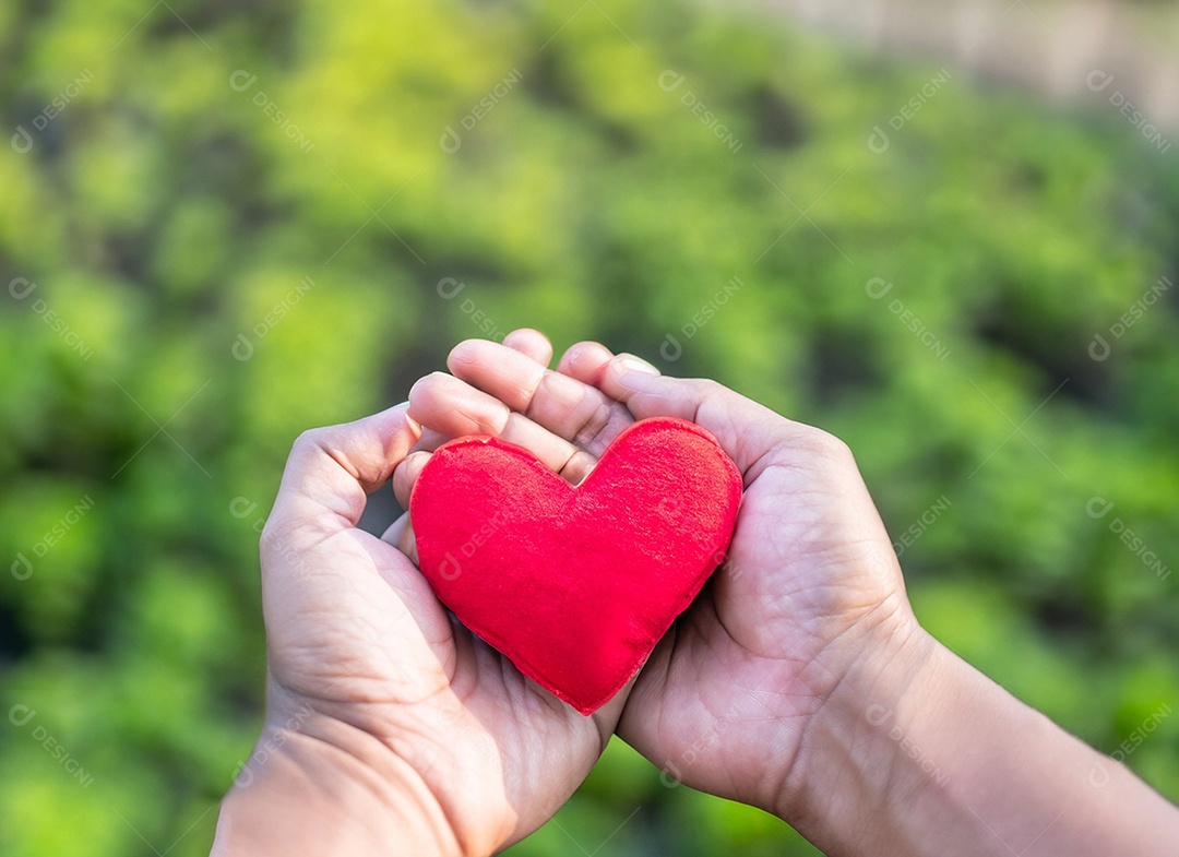 Mãos segurando um coração vermelho